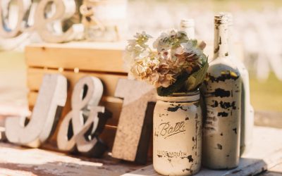 White old bottles with beige flowers stand before wooden newlewe