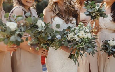 Bride and bridesmaids with pastel bouquets stand side by side